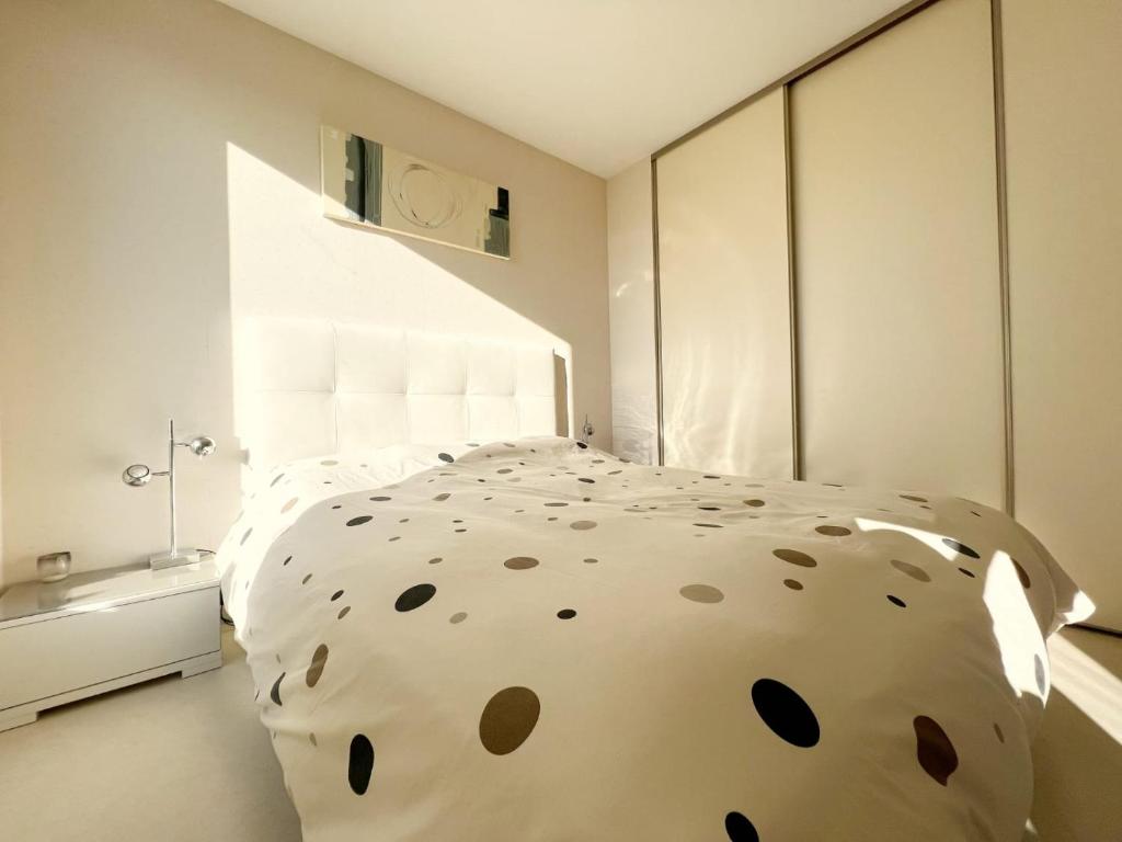 圣埃尔布兰Le panoramique的卧室配有一张白色大床和波卡圆点
