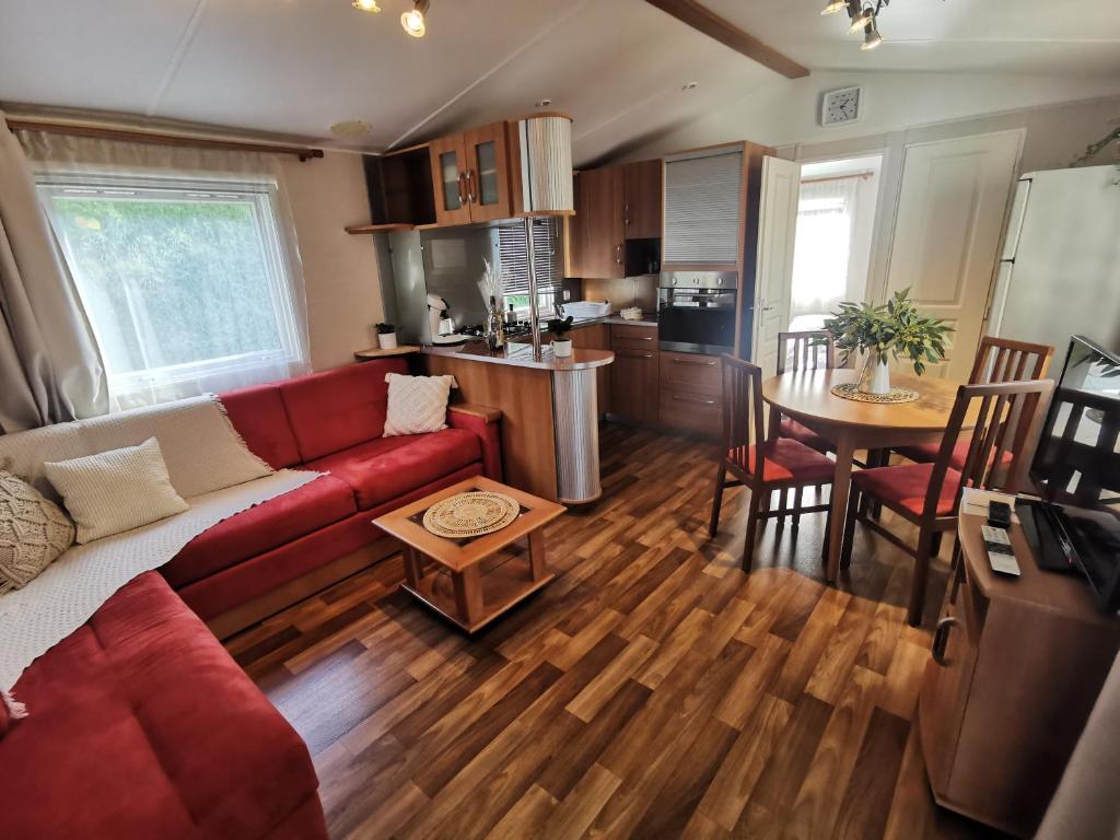 Saint-Martin-PlageMobil Home proche de la mer的一间带红色沙发的客厅和一间厨房