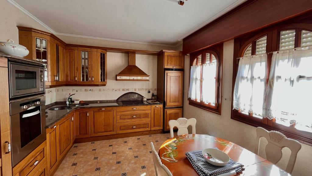 伊巴兰格鲁Villa Artegoikoa的厨房配有木制橱柜、餐桌和用餐室