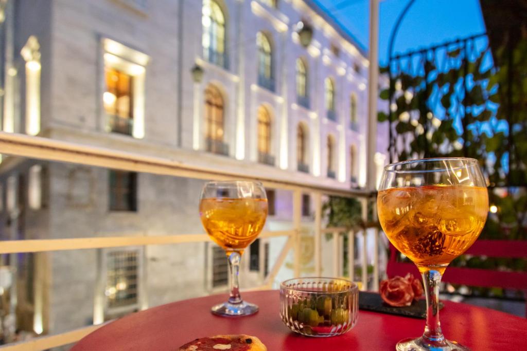 那不勒斯Residenza Toledo Lifestyle的两杯酒坐在桌子上,窗户