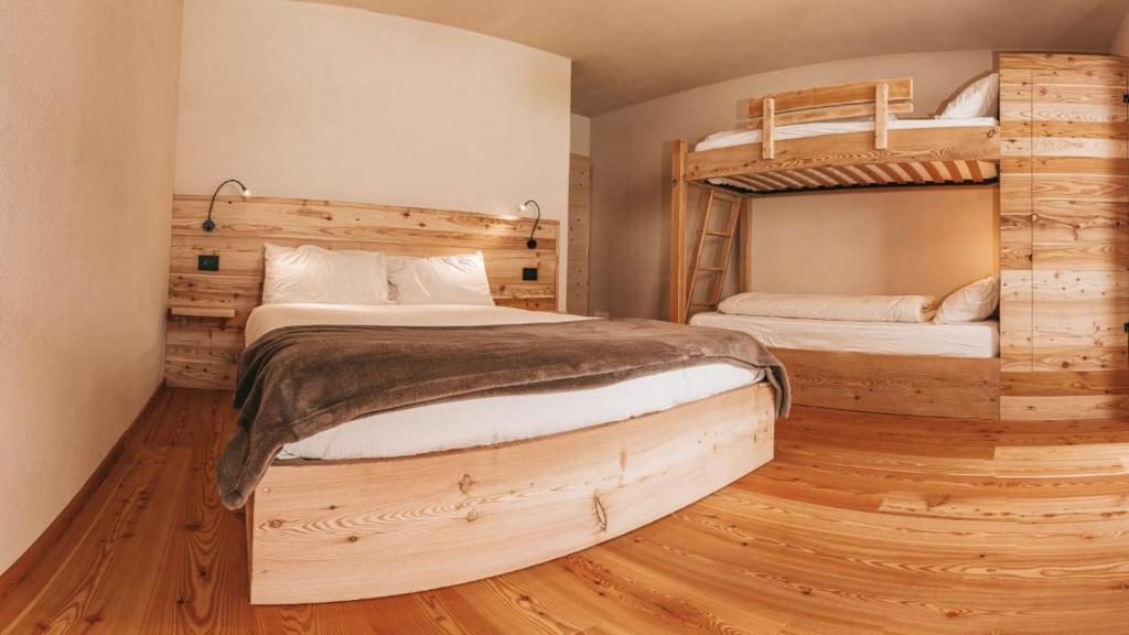 平佐洛B&B Maso Ghirola的铺有木地板的客房内配有两张双层床。