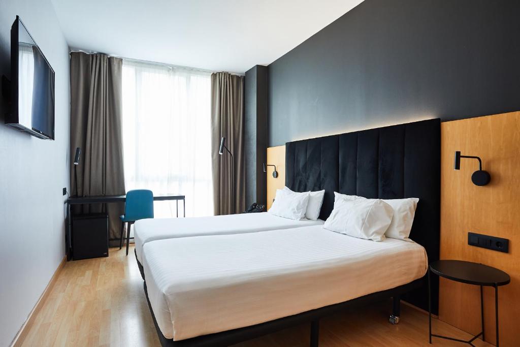 巴塞罗那西尔肯圣格瓦西酒店的酒店客房带一张大床,带白色床单
