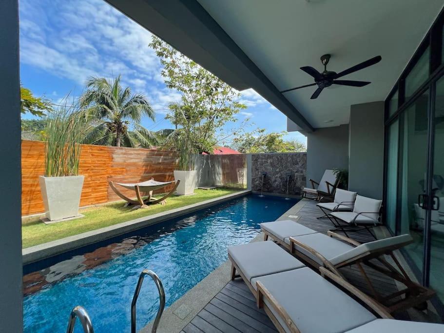 珍南海滩La Mer Luxury Villa - Private Pool Langkawi的一个带椅子和吊扇的游泳池