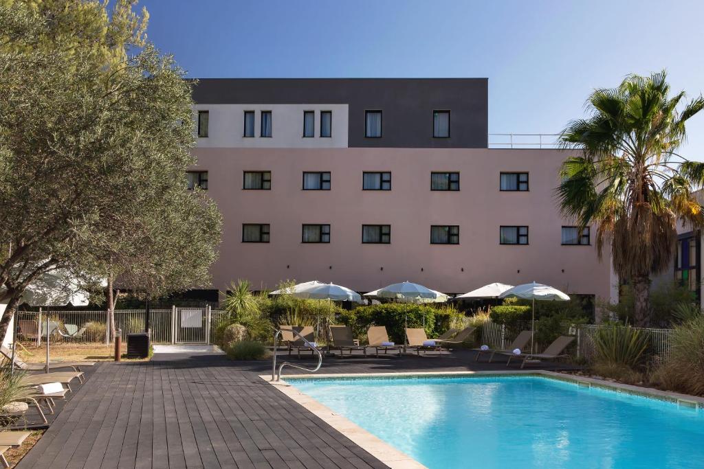 维特罗勒金色郁金香马赛机场酒店的大楼前设有游泳池的酒店