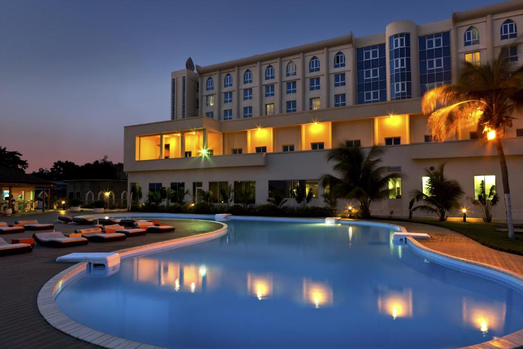 科托努Azalaï Hôtel Cotonou的一家在晚上设有大型游泳池的酒店