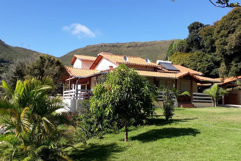卡舒埃拉坎普Sítio da Serra em Ouro Preto MG的前面有一座绿色庭院的房子