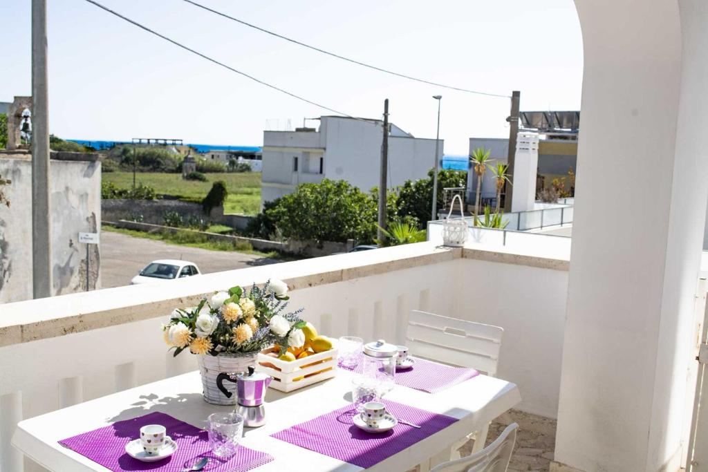 佩斯科勒海滨Appartamenti in Via Schipa Pescoluse的阳台上的白色桌子和花瓶