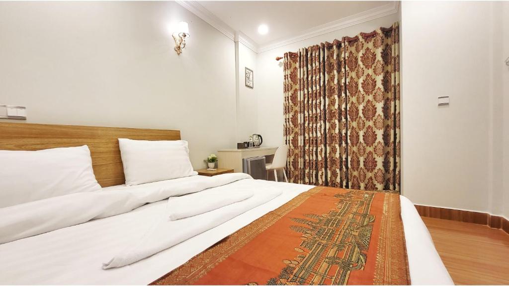 西哈努克LK Apartment & Hotel的一间卧室配有一张大床和窗帘