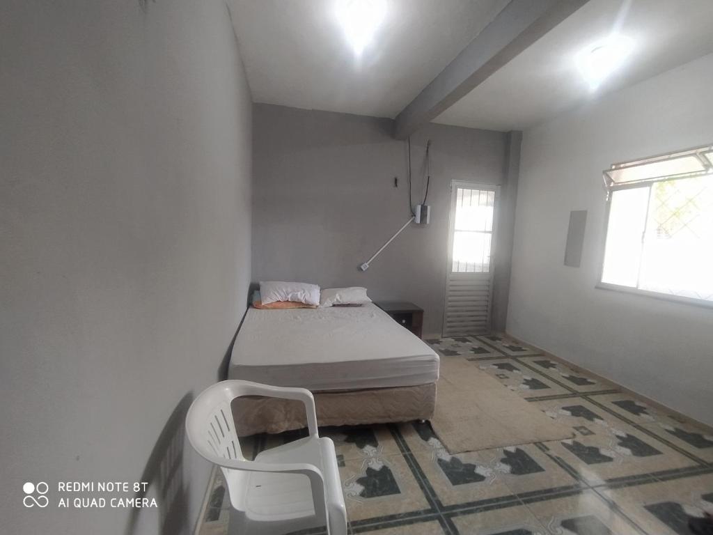 贝伦Casa Ariramba Mosqueiro的一间卧室配有一张床和一把椅子