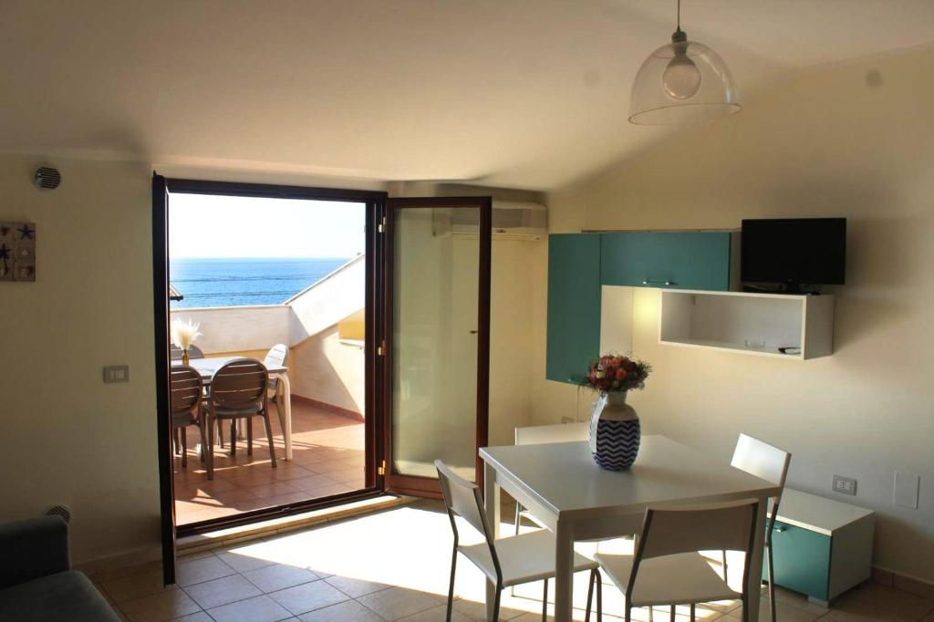 阿曼泰阿Il Borgo della Marinella Case Vacanze的一间厨房和带桌子的海景用餐室