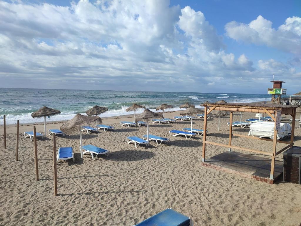 米哈斯科斯塔Holiday1的海滩上的一组椅子和遮阳伞