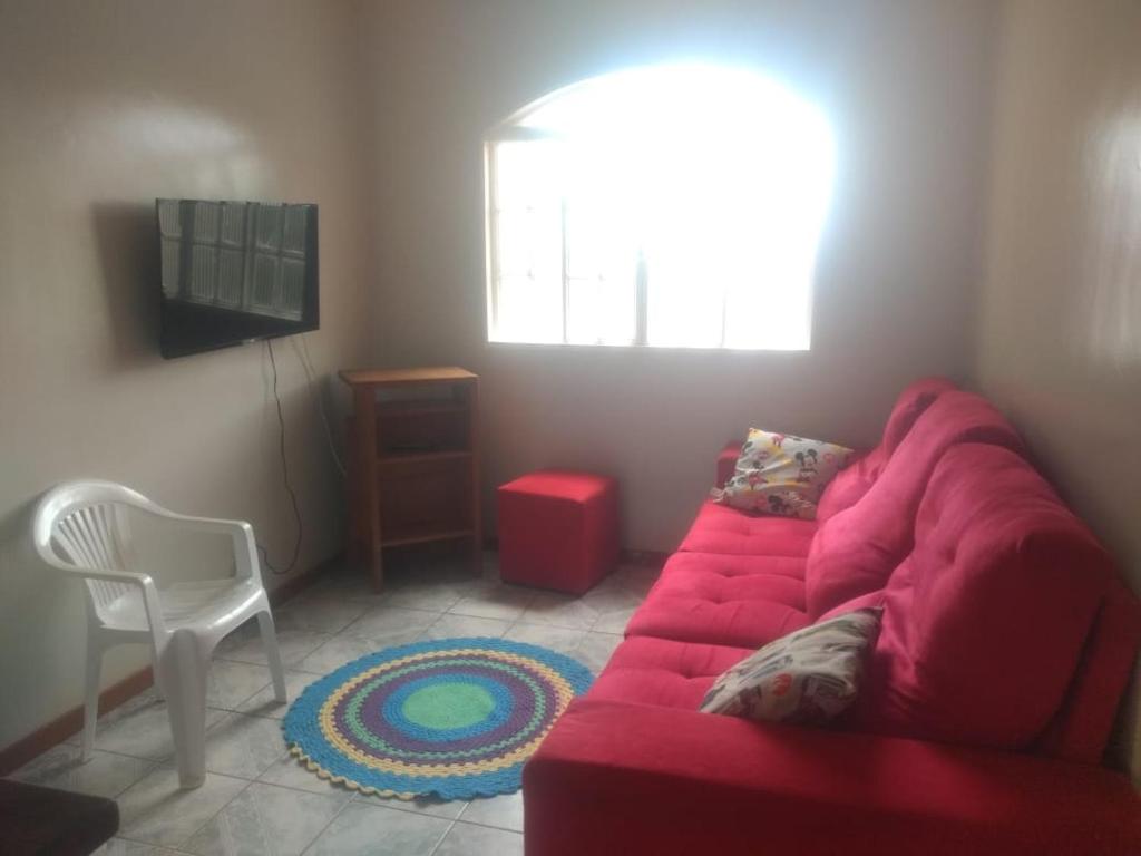 巴西利亚Hospedaria Chaves的客厅配有红色的沙发和椅子
