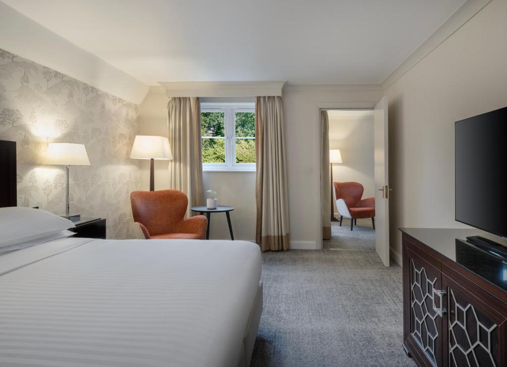 沃尔斯雷Delta Hotels by Marriott Worsley Park Country Club的酒店客房,配有床和电视
