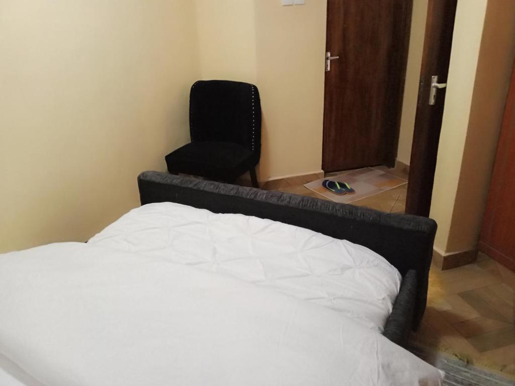 MeruCeeJ'S Airbnb的一间卧室配有一张床和一张黑椅