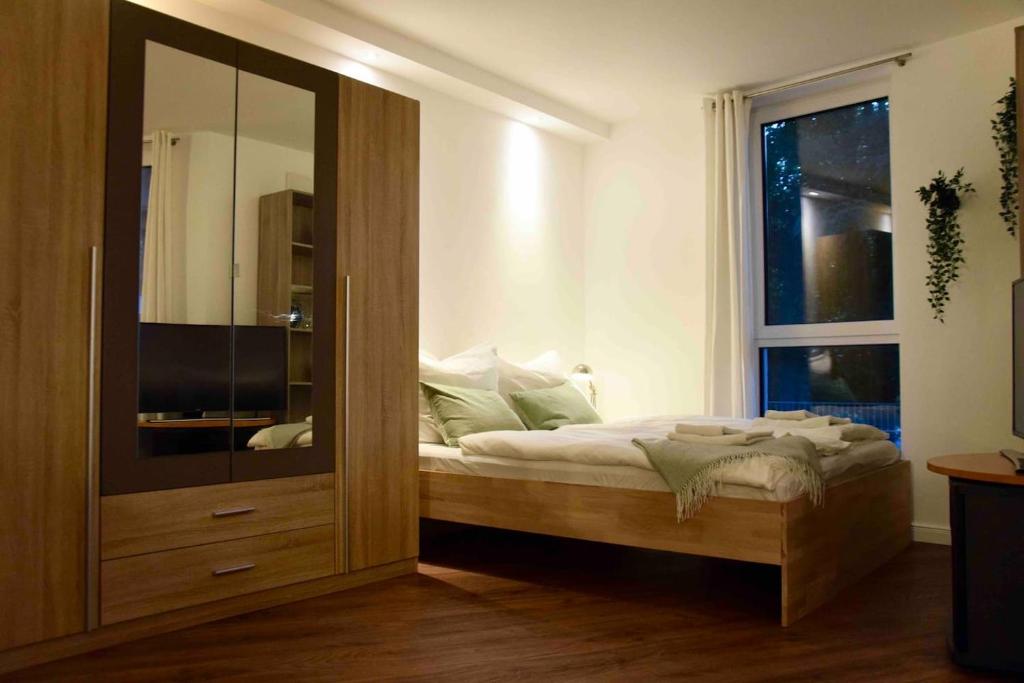 罗斯托克Stilvolle Wohnung mit Balkon & Parkplatz的一间卧室配有床和大型玻璃柜