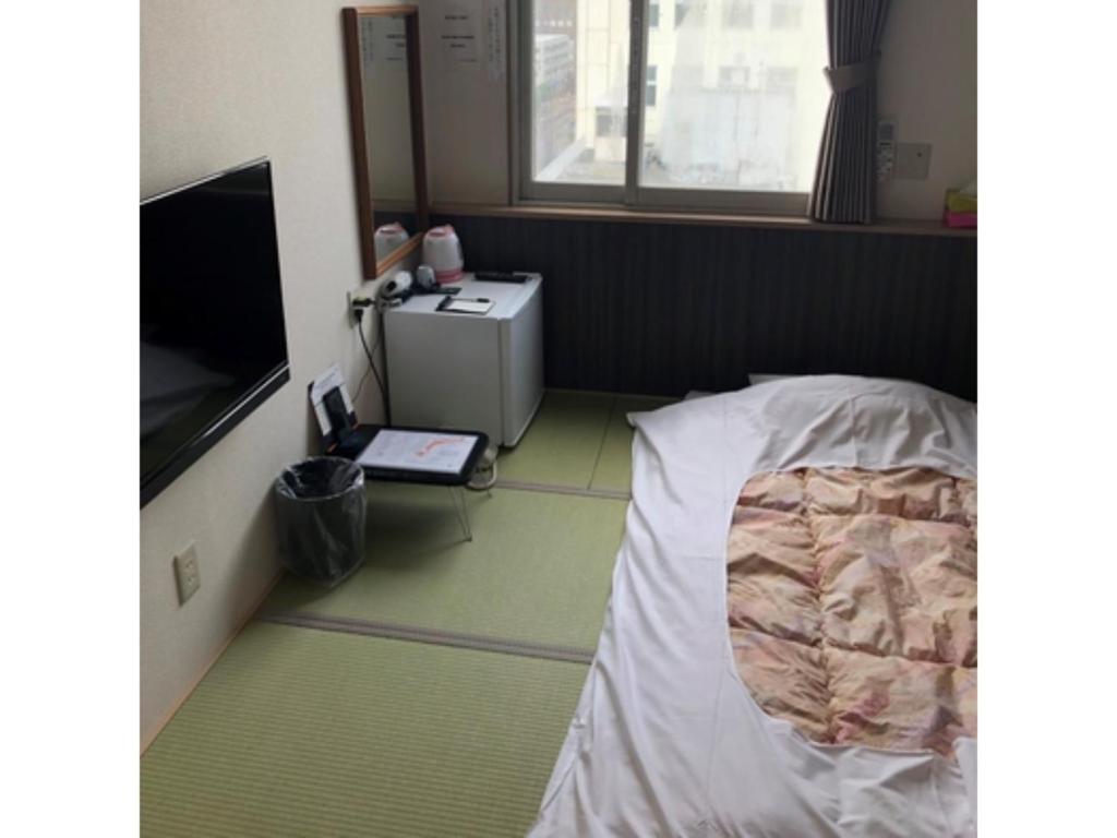 旭川HOTEL TETORA ASAHIKAWA EKIMAE - Vacation STAY 91508v的配有床和电视的房间