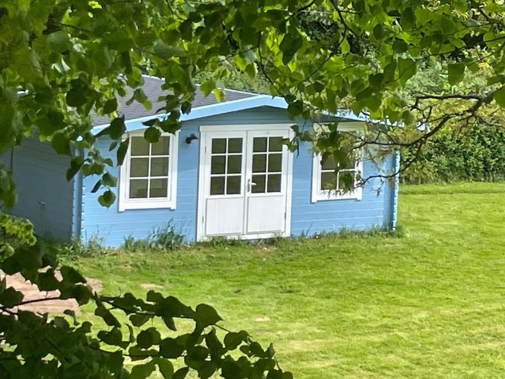 MayboleOak View Lodge: Cosy, Countryside Retreat的院子里的蓝色房子,有白色门
