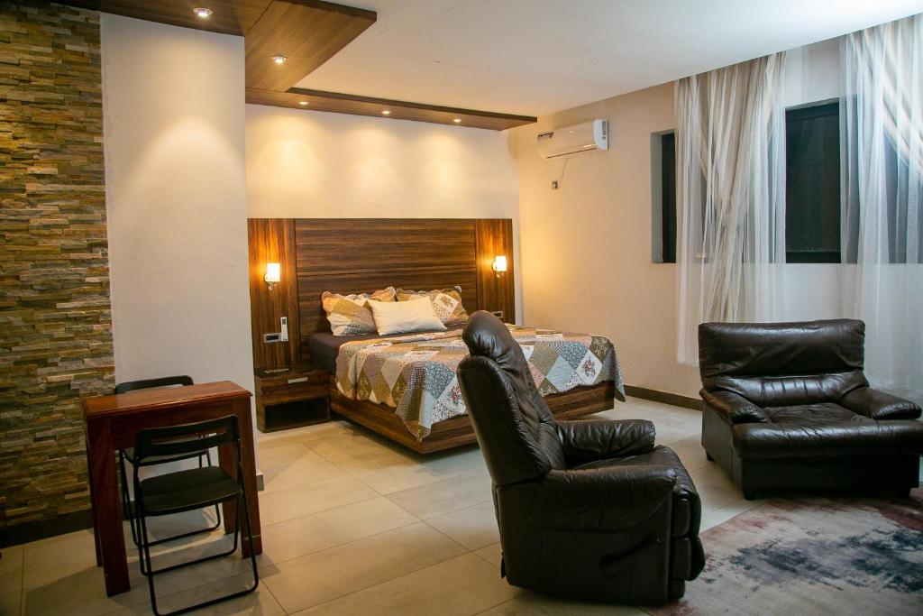 BueaToilcam的一间卧室配有一张床、一张沙发和一把椅子