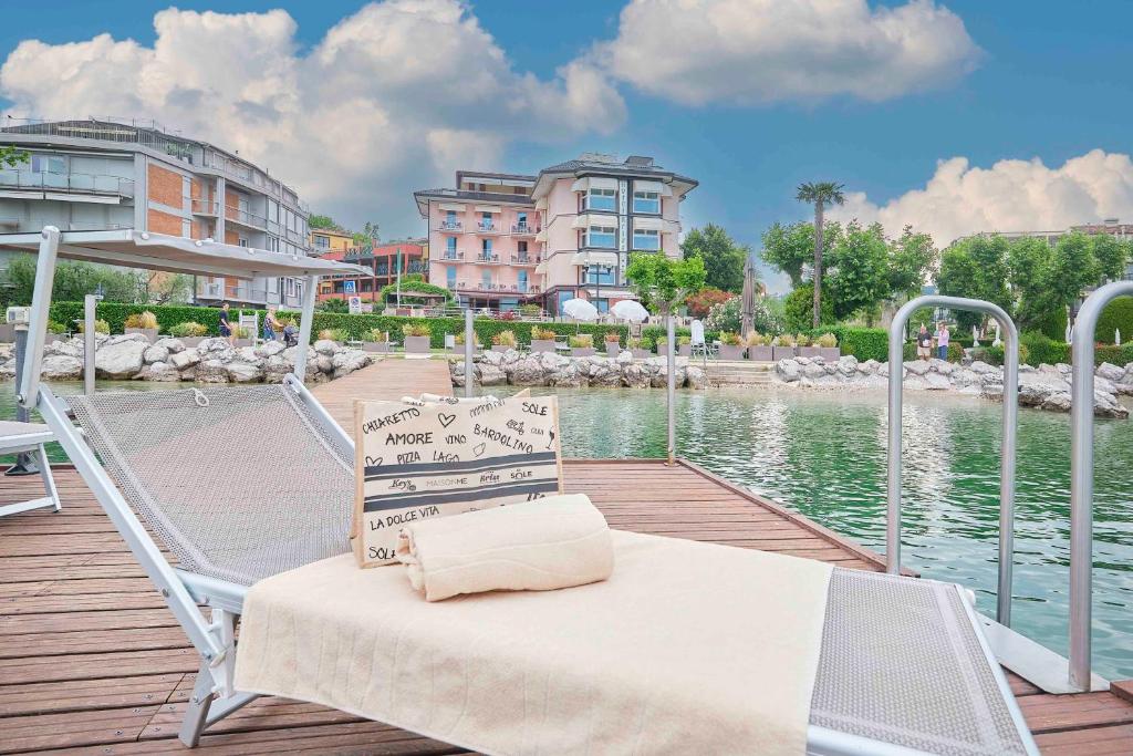 巴多利诺科瑞思国际酒店的坐在水体旁边的码头上的椅子