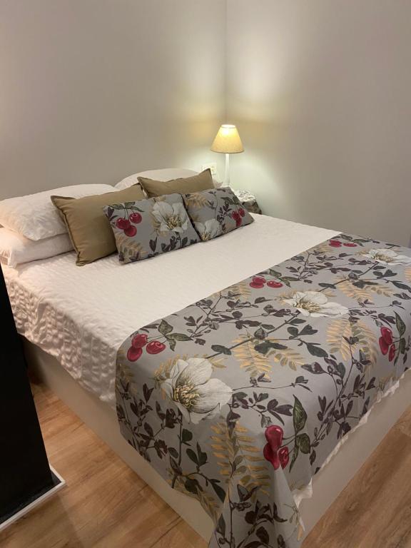 萨拉戈萨Precioso y céntrico apartamento的一间卧室配有一张带花卉图案的毯子的床