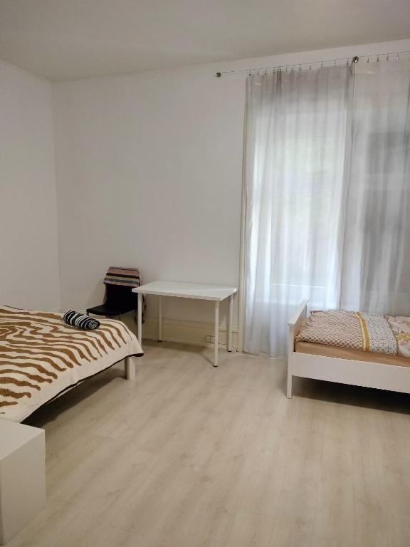 苏黎世City Home Zurich的客房设有两张床、一张桌子和一扇窗户。