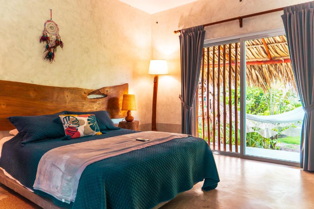 El Paredón Buena VistaKa´ana Surf的一间卧室设有一张床和一个大窗户