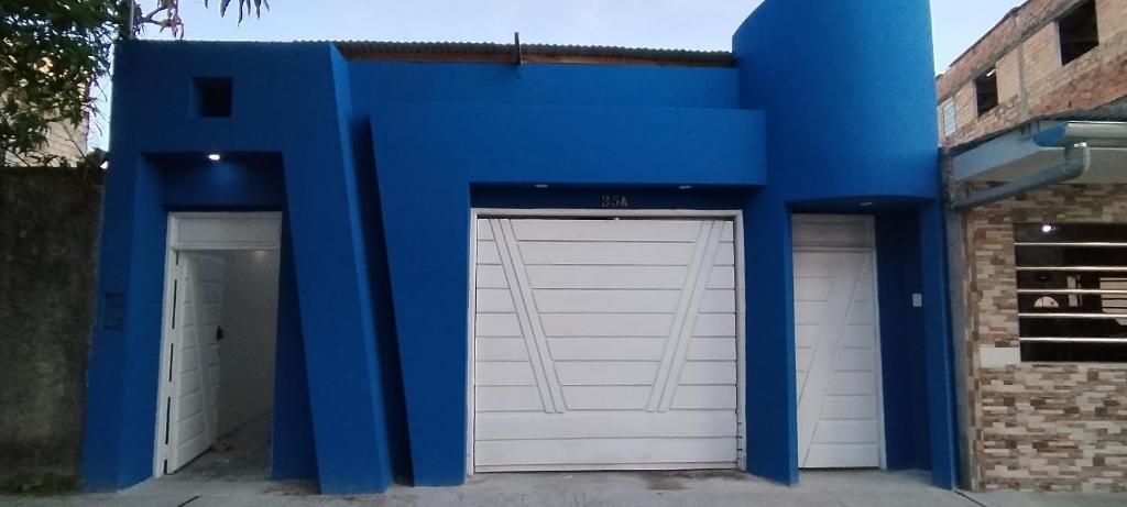 伊基托斯La casita Azul - Río Mar - Iquitos的蓝色建筑中的一对车库门