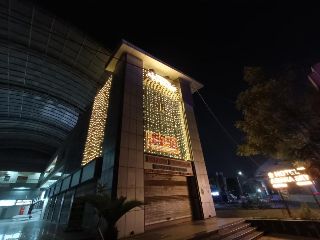 艾哈迈达巴德HOTEL ASIANA SKY Motera Ahmedabad的一座晚上有标志的建筑
