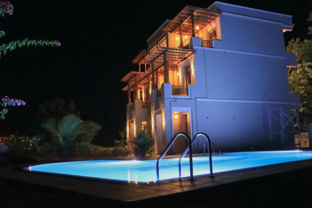阿鲁甘湾Paddyway Resort的夜间在房子前面的游泳池