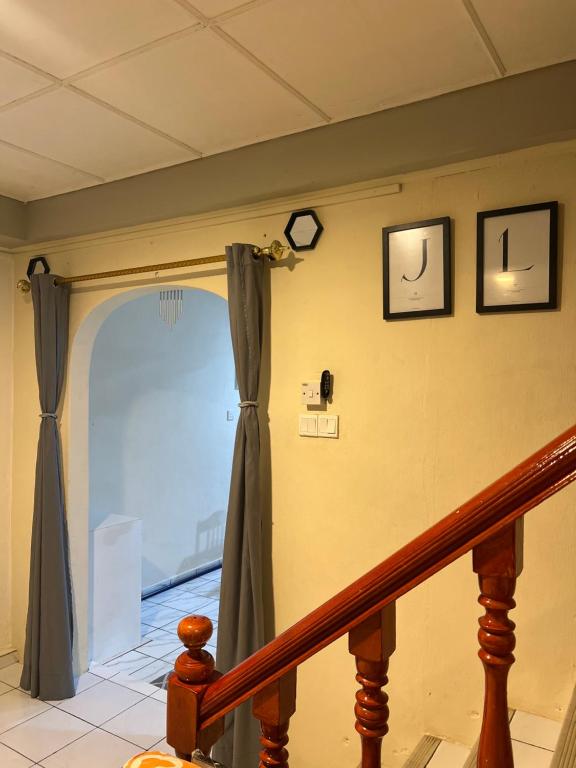 拿笃JL Homestay Taman Pertama Satu的一间设有楼梯的房间,配有窗帘和窗户