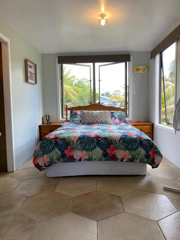 阿洛菲David's Fale, Alofi, Niue的一间卧室配有一张带五颜六色棉被的床