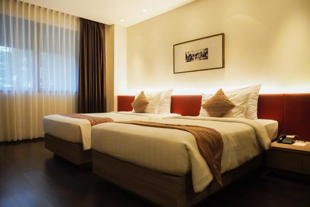万隆万隆爪哇酒店的酒店客房设有两张床和窗户。