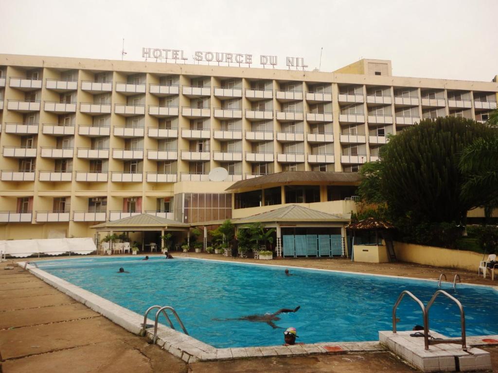布琼布拉Hôtel Source Du Nil的大楼前设有游泳池的酒店