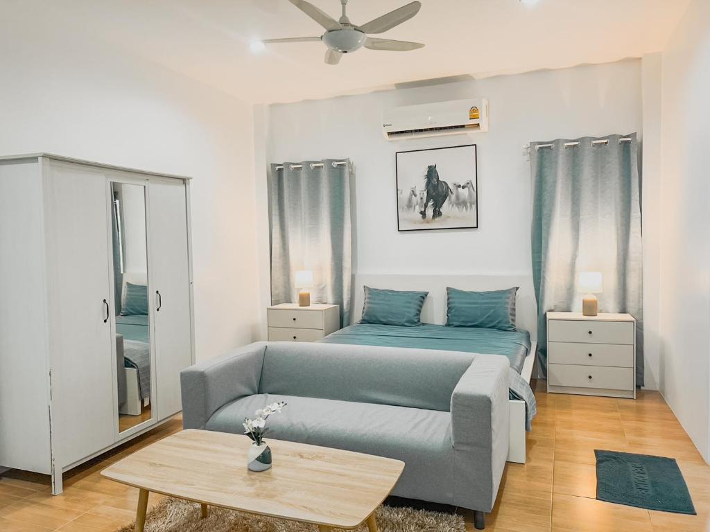 拉威海滩Rawai Valley Resort的客厅配有沙发和1张床