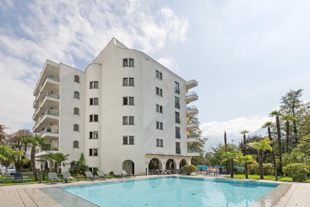 洛迦诺阿尔拉戈公寓酒店的大楼前设有游泳池的酒店