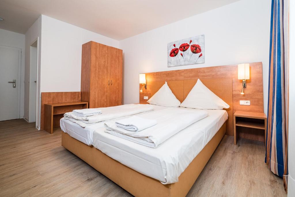 多特蒙德G & L Hotel Dortmund的一间卧室配有一张带白色床单的大床