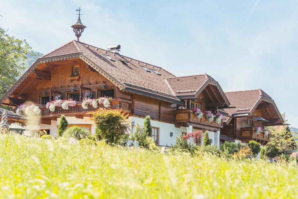 圣吉尔根Ferienwohnung Schossleitner - der Wohlfühl-Ansitz am Wolfgangsee mit Weitblick的阳台上带鲜花的大型木制房屋