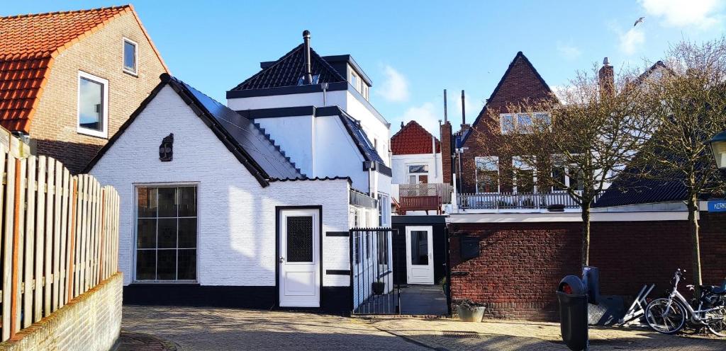 赞德沃特B&B de Drukkerij Zandvoort - luxury private guesthouse的一座带门和砖砌建筑的白色房子