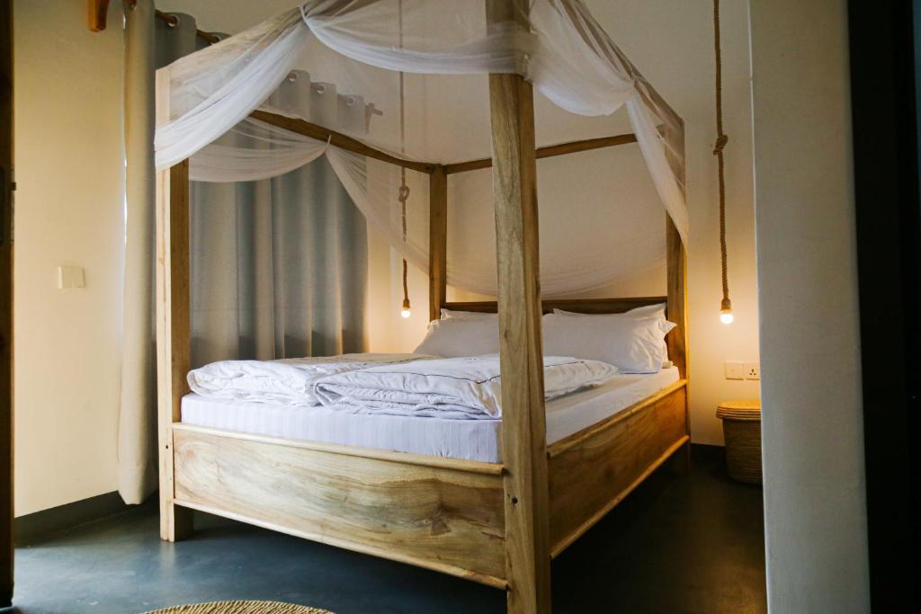 阿鲁沙Hakuna Woga Inn的一间卧室配有一张带白色床单的木制双层床