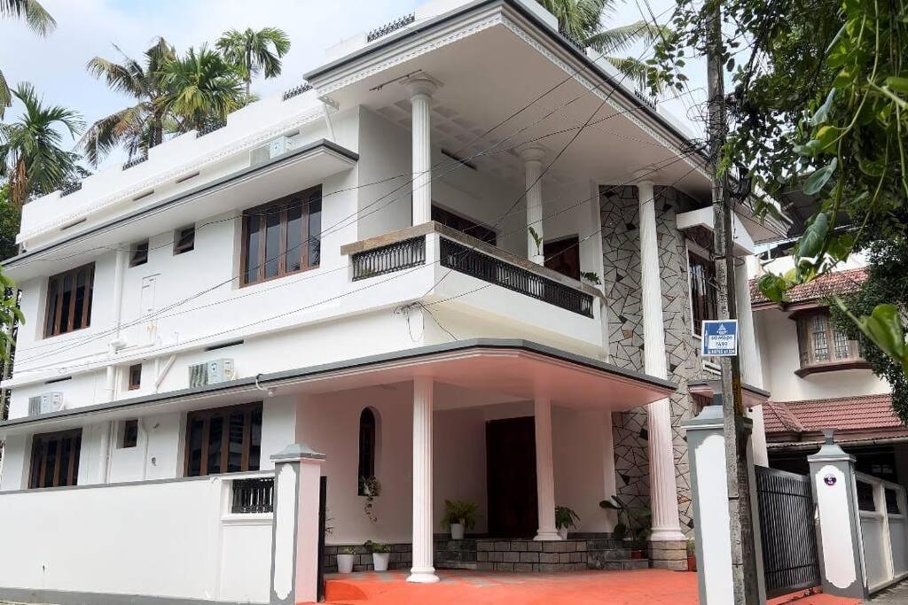 科钦Hosted by Resmi Jayalal的街道上一座大型白色建筑,设有阳台