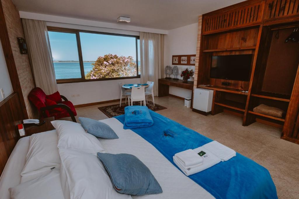 伊塔波阿Partner Itapoa by Marina的一间卧室设有一张大床,享有海景