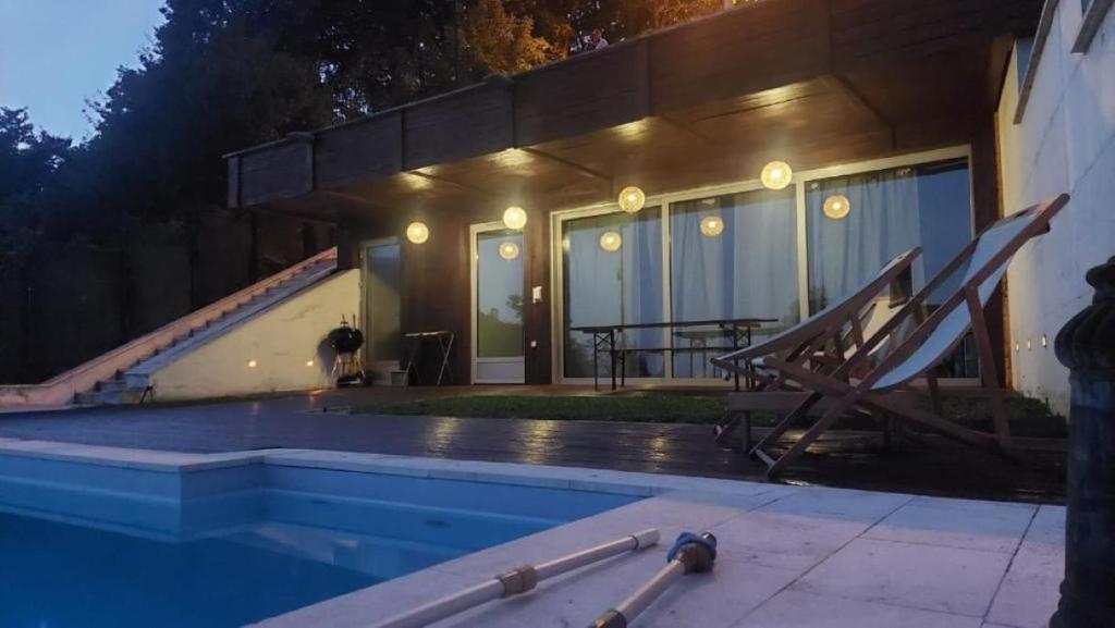 萨格勒布ZAGREB HOUSE MEDVEŠČINA/WITH POOL的一座晚上设有游泳池的房子