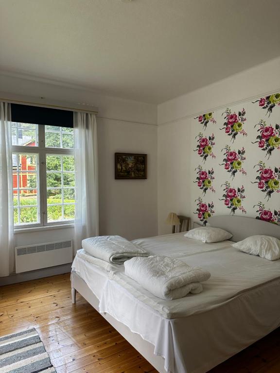 ÄlvkarlebyOfficersvillorna, Älvkarleby Vandrarhem的卧室配有两张挂有鲜花的床。