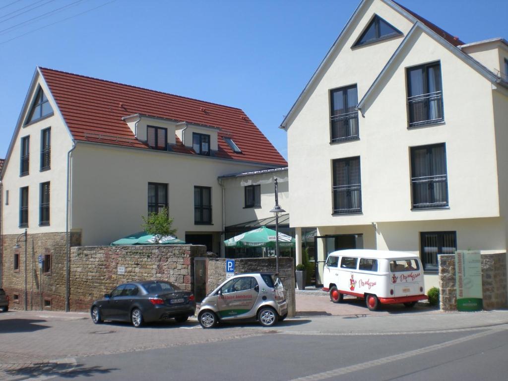Das kleine Amtshotel的停在大楼旁边的停车场的两辆车