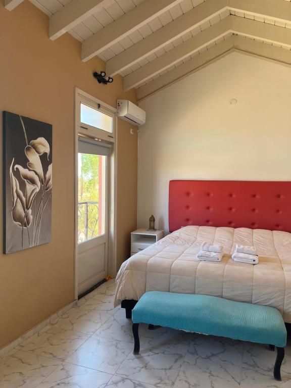 巴雷阿尔Posada Villa Pituil的一间卧室配有一张大床和红色床头板