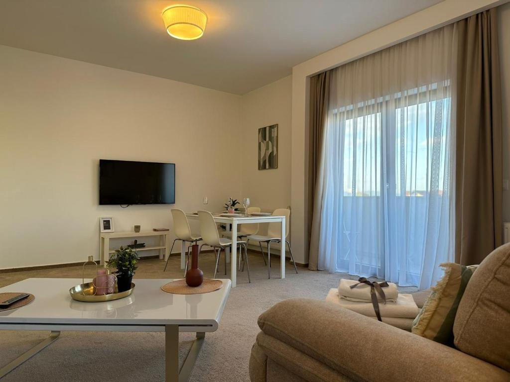 布拉索夫Luxury Glam Apartments & Studios near Coresi Mall的客厅配有沙发和桌子