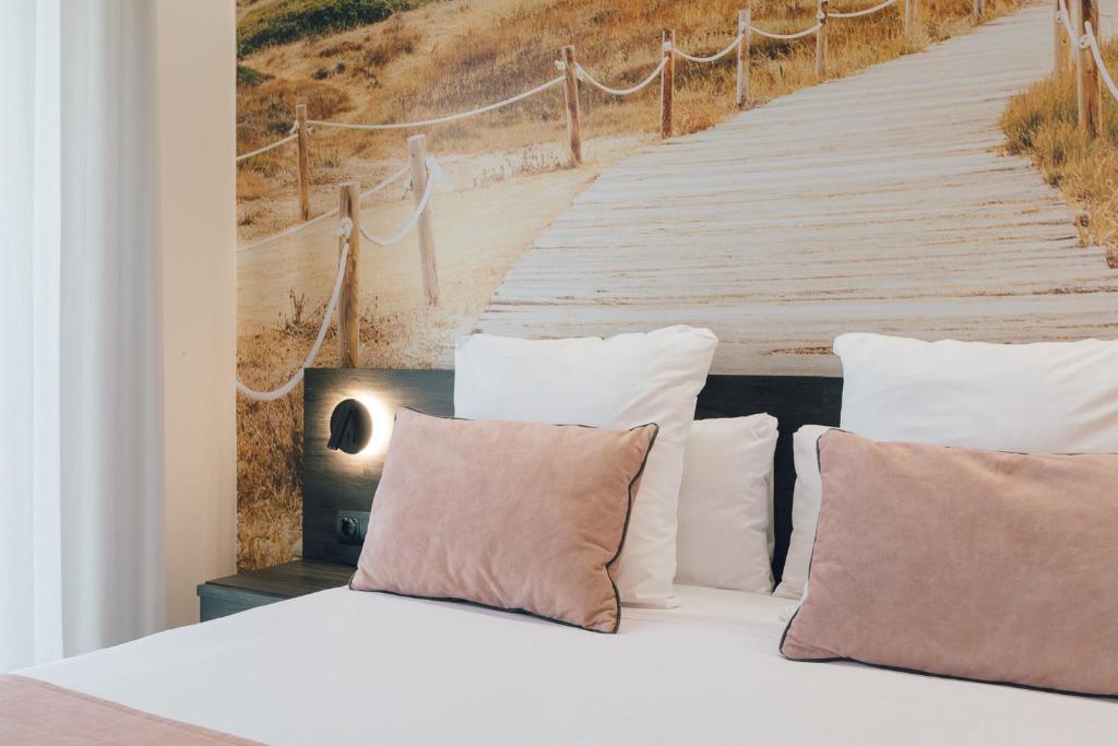 瓦伦西亚Palau Apartments Valencia的一张带枕头的床和一张木板路画