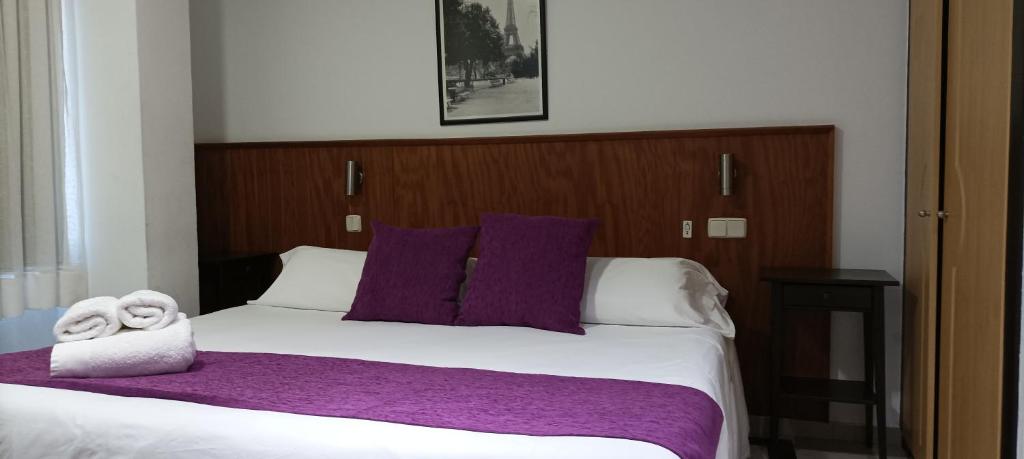 马亚达洪达伊莎贝尔夫人旅馆的一间卧室配有一张大床,提供紫色床单和枕头