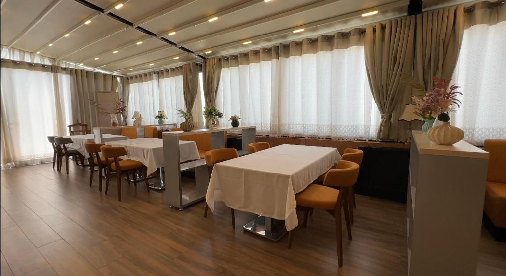 布哈拉Hotel Bukhara的一间设有白色桌椅的用餐室
