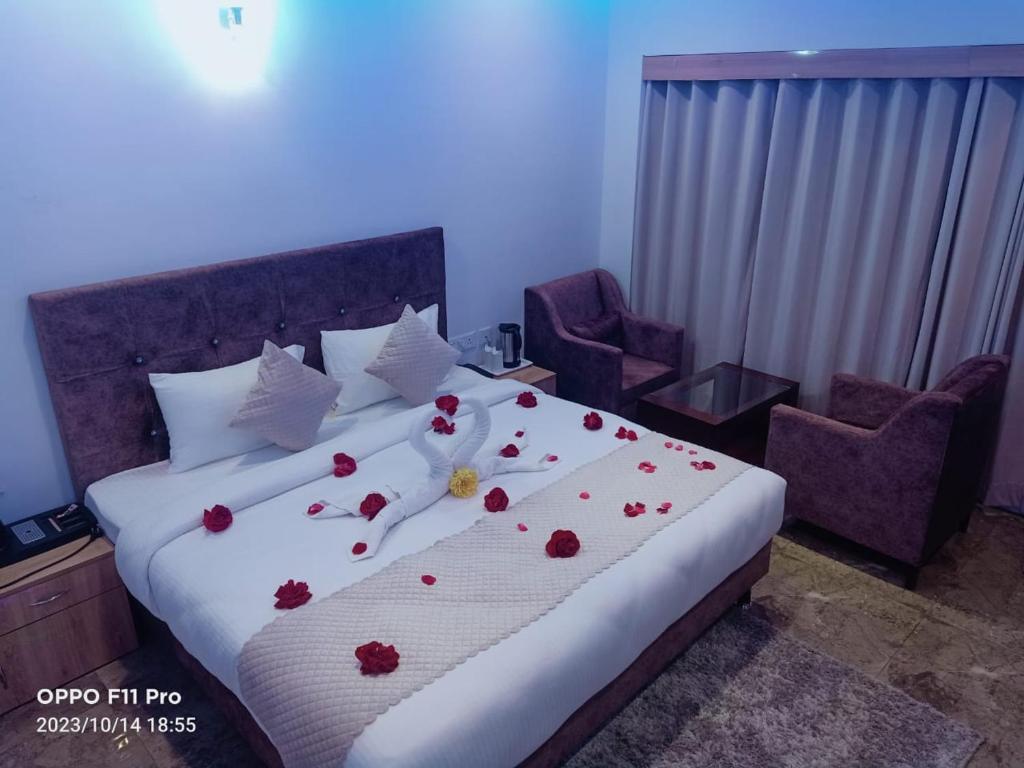 西姆拉Hotel candlewood Shimla的一间卧室,床上有红色的鲜花